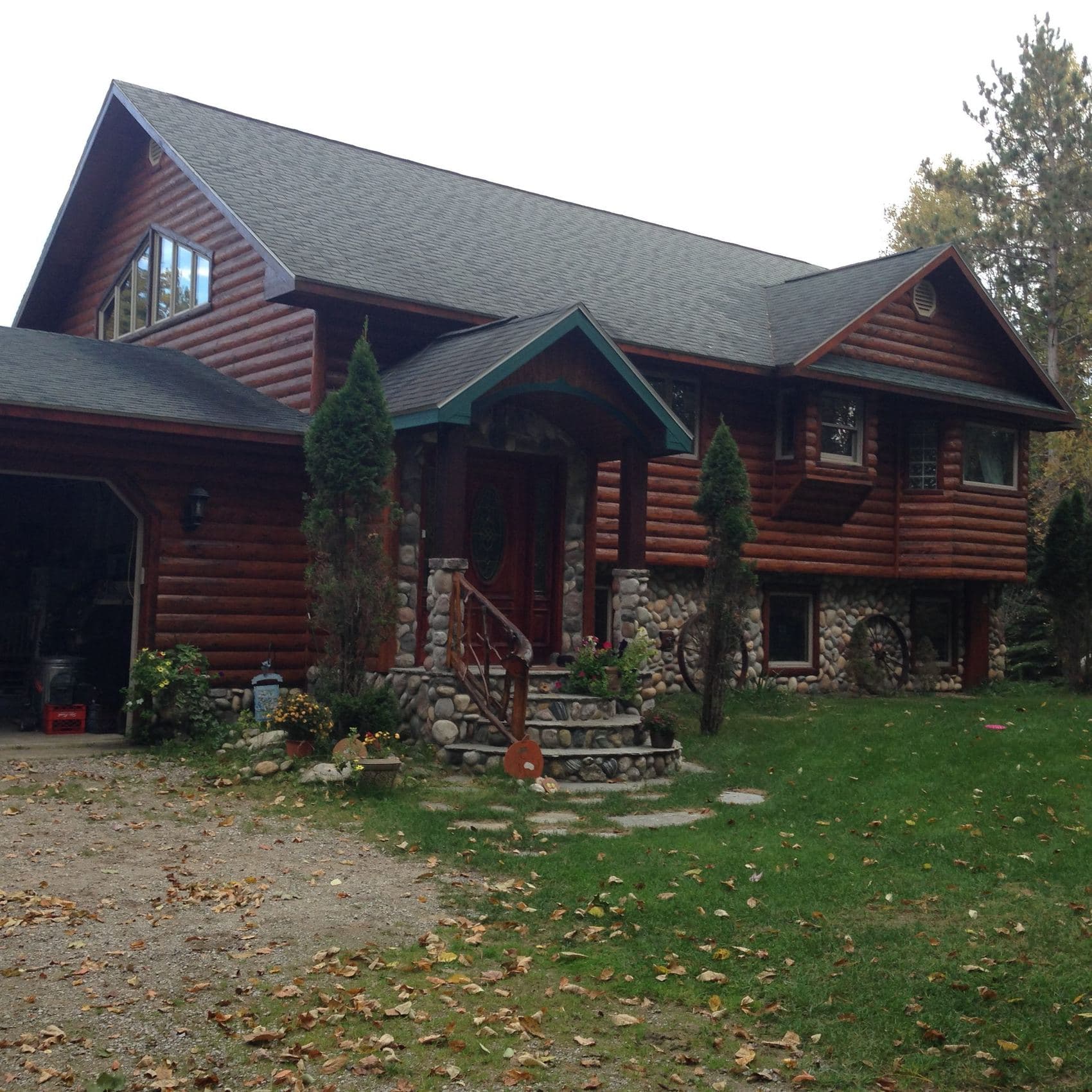 Log cabin after re-siding and staining by TNT Construction