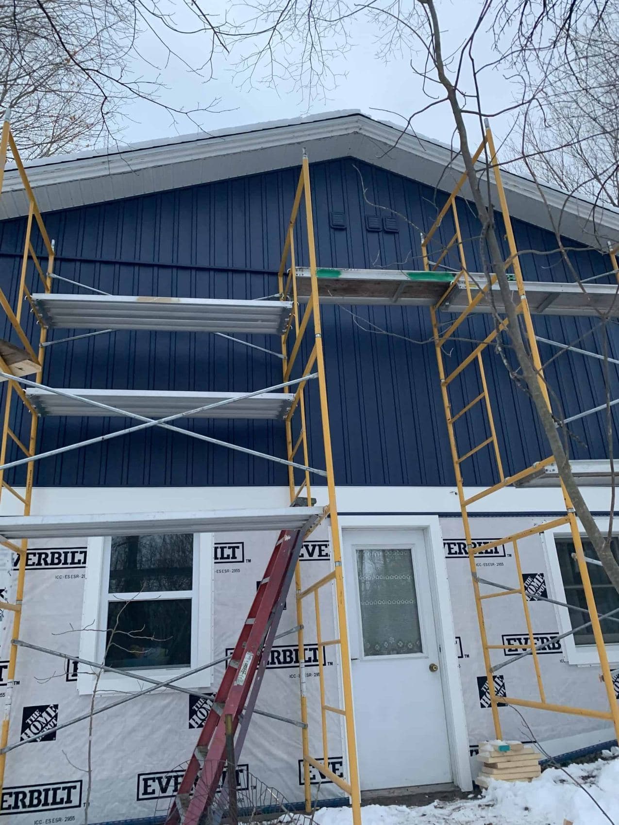 Crew on scaffolding installing siding in Boyne City