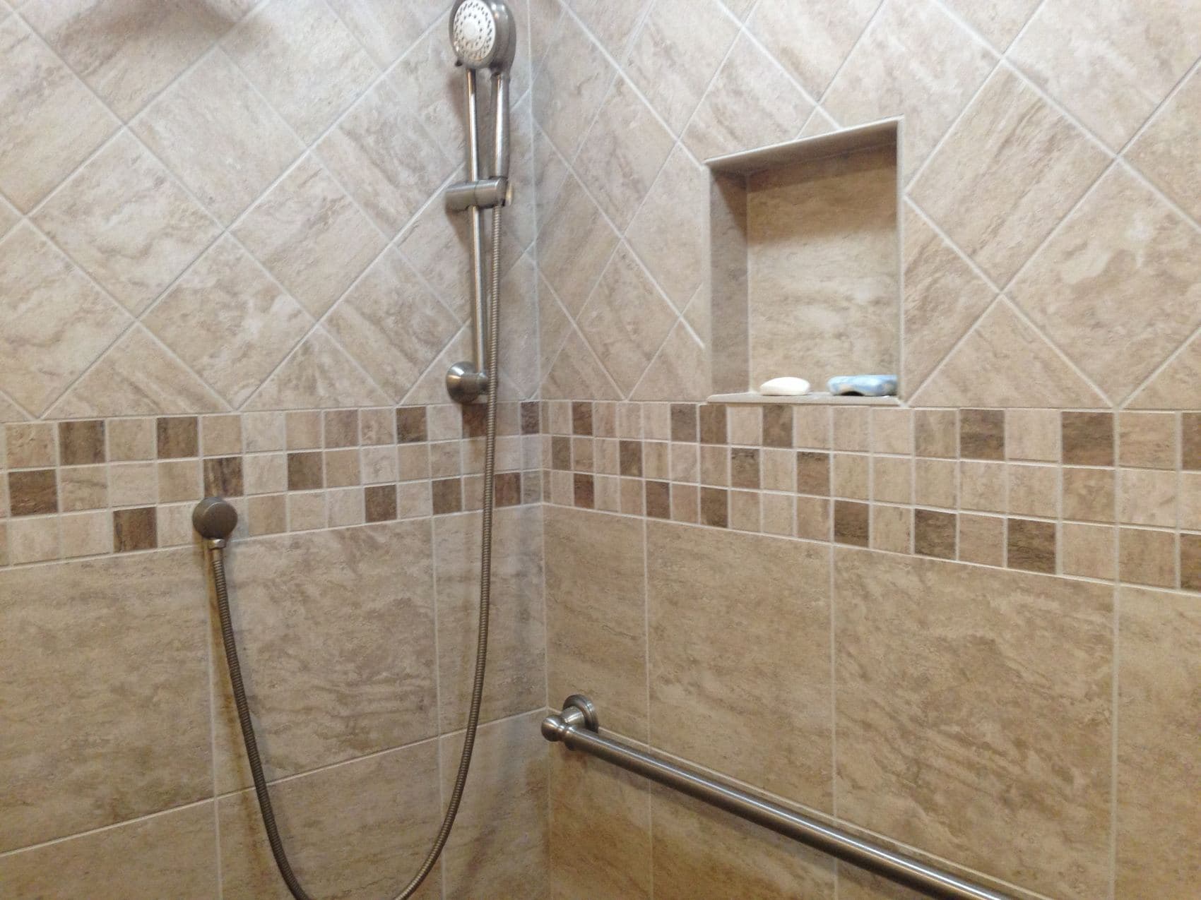 Remodeled bathroom with a custom tile shower and niche